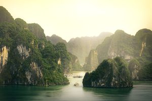 Jonque traditionnelle naviguant entre les pics karstiques de la baie de Lan Hạ