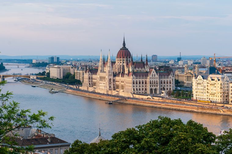 Le Parlement hongrois illuminé au bord du Danube à la tombée de la nuit
