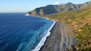 La tour génoise de Nonza surplombant la mer et la plage noire