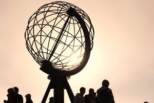Le célèbre globe en métal du Cap Nord face à l'océan Arctique sous un ciel nuageux