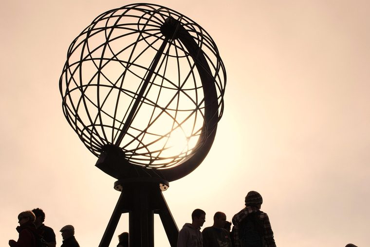 Le célèbre globe en métal du Cap Nord face à l'océan Arctique sous un ciel nuageux