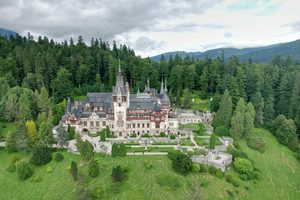 Les façades néo-Renaissance du château de Peleș entourées par la forêt des Carpates
