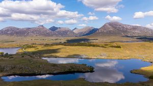 Les lacs sombres et les montagnes verdoyantes du Connemara sous un ciel nuageux