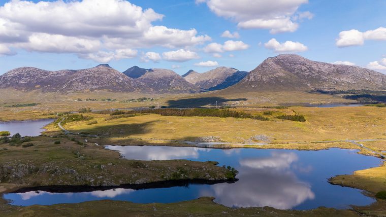 Les lacs sombres et les montagnes verdoyantes du Connemara sous un ciel nuageux