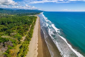 La longue plage de Dominical bordée par la jungle luxuriante