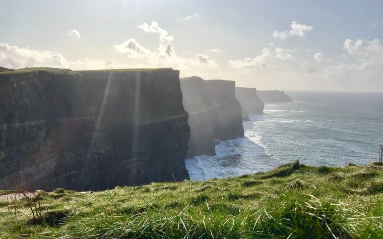 Les falaises de Moher plongeant dans l'océan Atlantique sous un ciel nuageux
