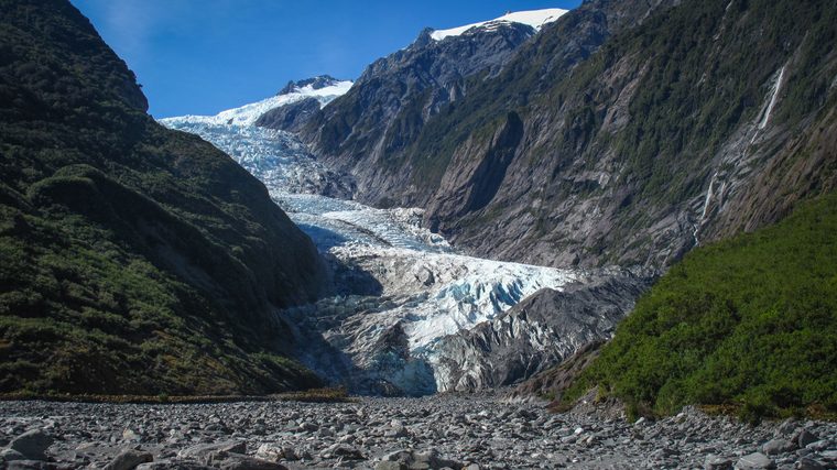 Vue aérienne d'une langue glaciaire serpentant jusqu'à la forêt tropicale