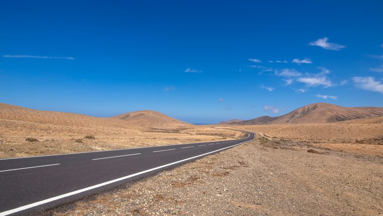 Route traversant les dunes de sable clair du parc naturel de Corralejo