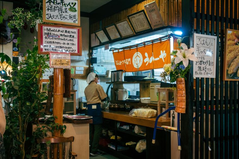 Les stands de nourriture yatai illuminés le long de la rivière Nakasu à la tombée de la nuit