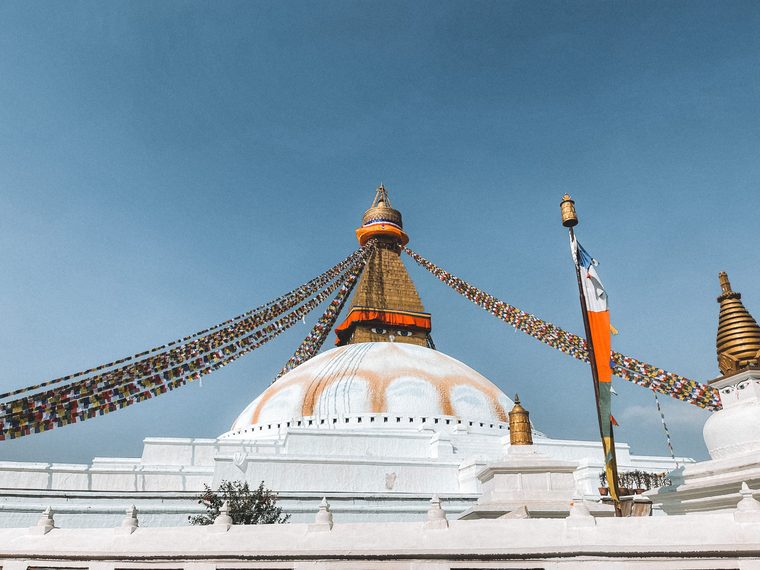 Le grand stupa blanc de Boudhanath orné de drapeaux de prières colorés