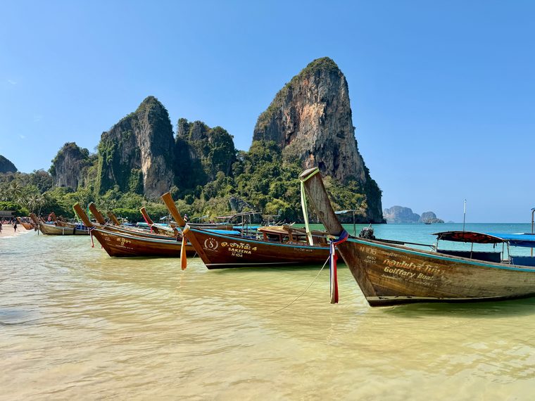 Les bateaux longue-queue traditionnels sur la plage de Railay à Krabi, entourés de pitons karstiques