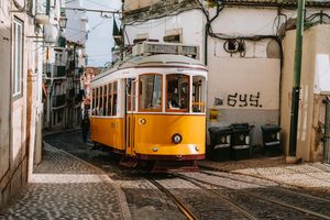 Un tramway jaune typique descendant une ruelle pentue de Lisbonne