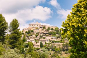 Le village perché de Gordes accroché à sa colline au soleil couchant