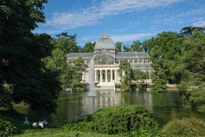 Le Palais de Cristal entouré d'arbres dans le parc du Retiro à Madrid