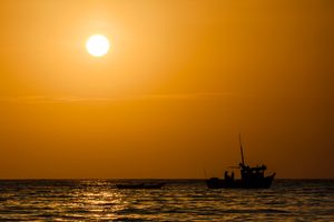 Coucher de soleil sur la plage de Máncora avec des surfeurs dans l'eau