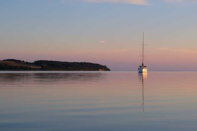 Un bateau naviguant paisiblement sur un lac bordé de forêts dans le Mecklembourg