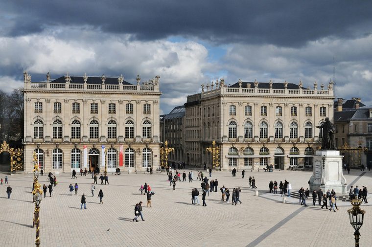 La place Stanislas éclairée à la tombée de la nuit avec ses grilles dorées