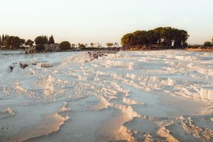 Les vasques blanches de travertin de Pamukkale remplies d'eau bleue au coucher du soleil