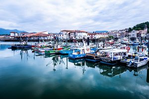 Le port de pêche de Saint-Jean-de-Luz avec les bateaux colorés et la Rhune en toile de fond