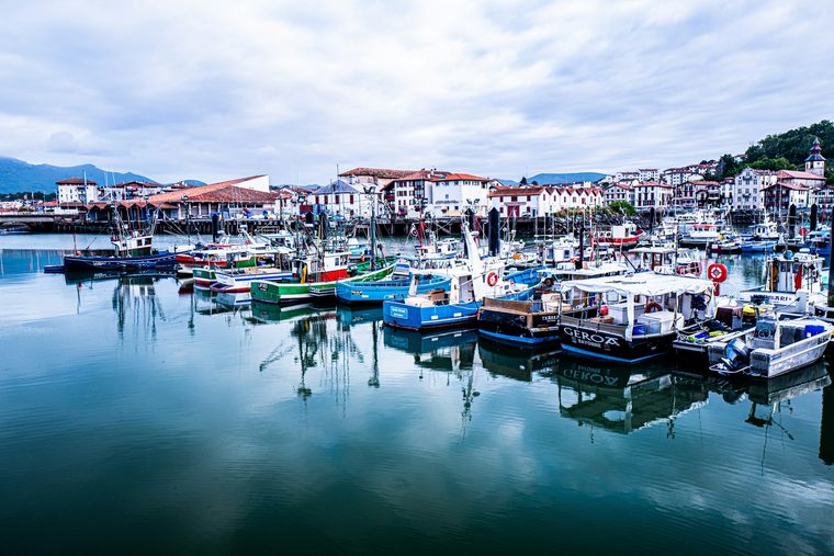 Le port de Saint-Jean-de-Luz avec les bateaux de pêche et les collines en arrière-plan