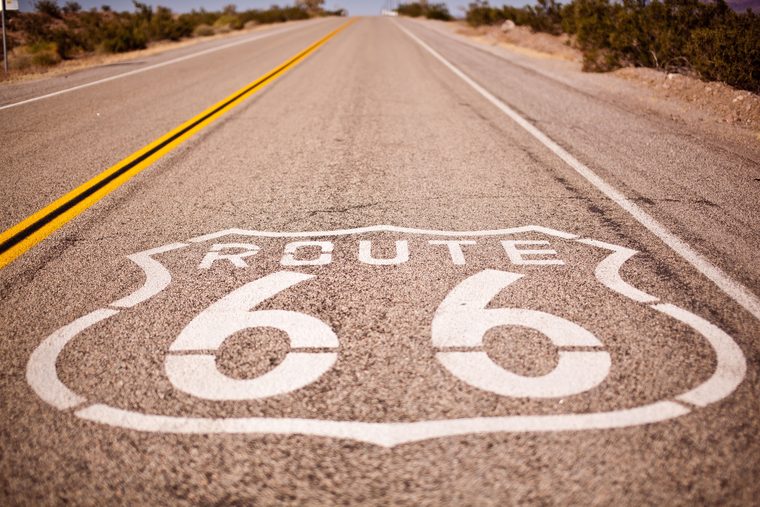 Panneau Route 66 peint sur l'asphalte dans le désert de Mojave