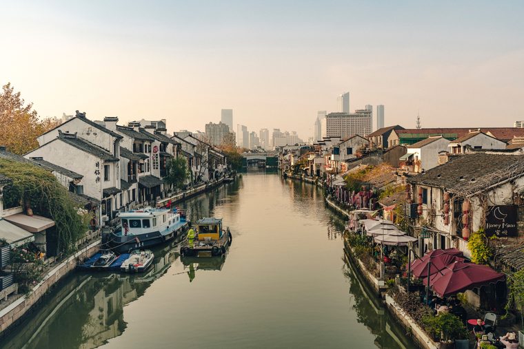Canal bordé de saules pleureurs et maisons traditionnelles à Suzhou