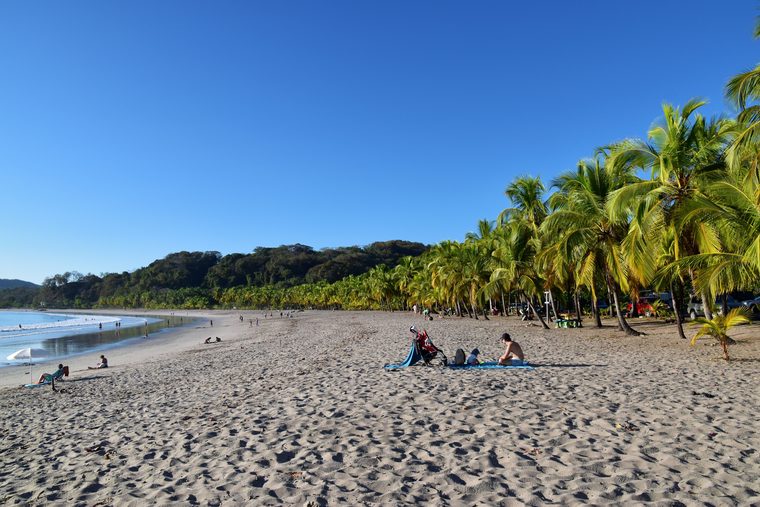 Coucher de soleil sur la plage de Tamarindo avec des surfeurs dans l'eau