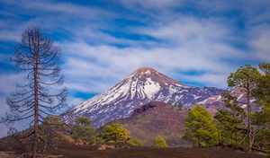 Le sommet enneigé du volcan Teide dominant une mer de nuages