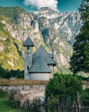 L'église de Theth entourée par les sommets escarpés des Alpes albanaises