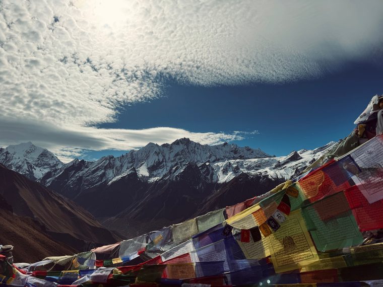 Vue sur les sommets enneigés et les drapeaux de prières depuis la vallée du Langtang