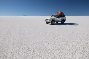 Un 4x4 traversant l'immensité blanche du Salar d'Uyuni