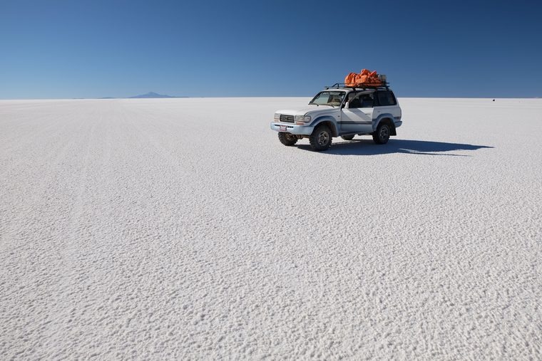Un 4x4 traversant l'immensité blanche du Salar d'Uyuni