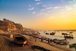 Barques sur le Gange au lever du soleil devant les ghats de Varanasi
