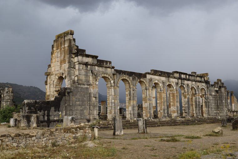 Les colonnes du Capitole de Volubilis se dressant au milieu des collines verdoyantes